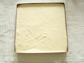 面糊从20CM高度倒入抹了薄薄一层玉米油的28*28烤盘中，晃平或者用刮板刮平，提起从高处振2下振出大气泡。