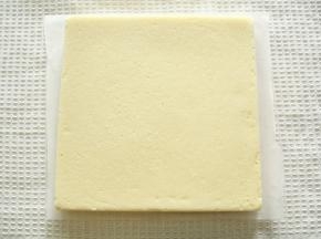 静置2分钟后盖油纸倒扣，抹油的模具可轻松脱模，毛巾面朝上晾至温热。