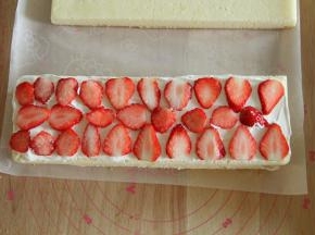 取一蛋糕片，抹上一层淡奶油，放上草莓片，再抹一薄层奶油，用抹刀抹平。
