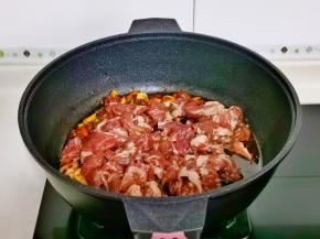 加入腌制好的梅花肉，翻炒至变色。