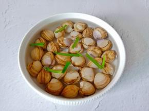 蛤蜊放入清水里加上一勺盐，葱段，食用油浸泡出泥沙。