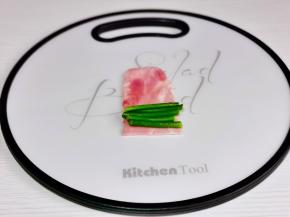 取一片培根，放上4-5根蒜苔。