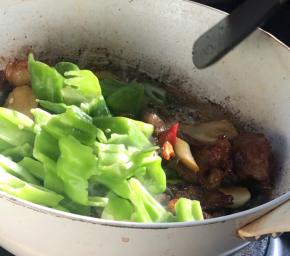 加入青蒜白和青椒块，翻炒均匀