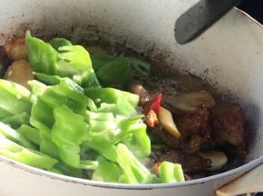 加入青蒜白和青椒块，翻炒均匀