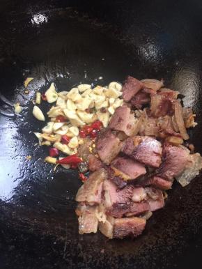 把腊肉扒到一边，放入花椒，生姜，蒜瓣，干辣椒爆香！
