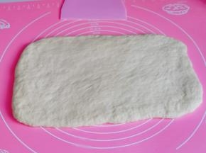 取一块松弛好的面团，用擀面杖擀长方形。