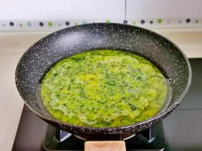 起油锅，倒入荠菜蛋液，中火煎，同时用筷子不停搅拌。