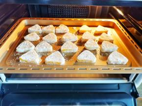 椰蓉酥摆入烤盘，放入提前预热好的烤箱，中层180度烤20分钟左右，至饼干周围上色即可。