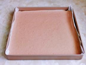 烤盘垫上油纸，倒入蛋糕糊震出气泡。