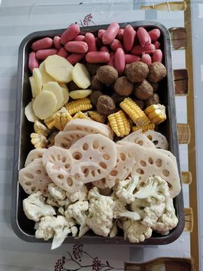 先把所需的食材处理好：
玉米洗净切成小块，藕和土豆削皮洗净切成厚一点的块，花菜洗净切成小朵，小火腿肠和肉丸清洗干净捞出沥干水分备用！