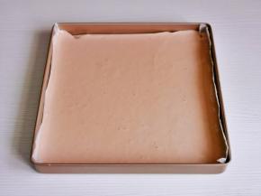 烤盘垫上油纸，倒入蛋糕糊震出气泡。