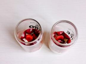 杯中放入一片蛋糕，挤入奶油，放入樱桃。