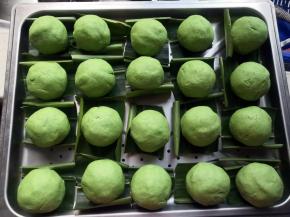 逐个包好，搓圆，摆上垫了山姜叶的蒸盘