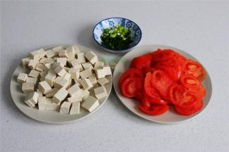 准备工作，西红柿划一个“十字”，用开水烫一烫，然后去皮，切片。豆腐用冷水浸泡，然后切小方块。香葱清洗干净，切好备用。豆腐用冷水浸泡，煮的时候不易碎，味道更好。