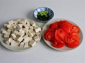 准备工作，西红柿划一个“十字”，用开水烫一烫，然后去皮，切片。豆腐用冷水浸泡，然后切小方块。香葱清洗干净，切好备用。豆腐用冷水浸泡，煮的时候不易碎，味道更好。
