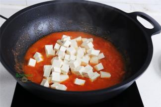 把切好的豆腐块，放入西红柿汤锅，再次用旺火煮沸，豆腐煮熟。我用的是老豆腐，不会碎，可以翻转一次，让西红柿汤汁全部浸没豆腐。