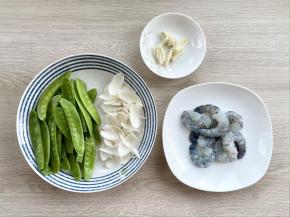 荷兰豆洗净，掐去头尾，撕掉老筋；百合洗净；剥掉大虾的头和壳，挑去虾线，洗净；大蒜切片备用。