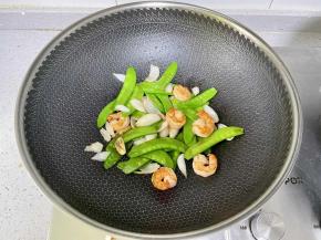 然后倒入百合和虾仁，继续翻炒5秒钟；