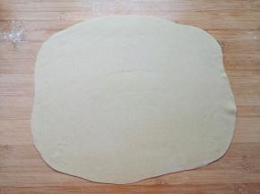 先取四分之一的面团，擀成一个接近长方形的大面片。 