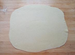 先取四分之一的面团，擀成一个接近长方形的大面片。 