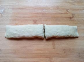 卷起来，用手压一下，从中间切开，一个生的韭菜卷就做好了，依次做完剩下的面团。 