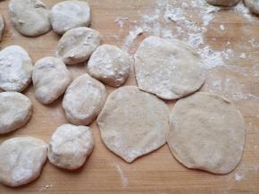 将小剂子压扁，擀成中间稍厚边缘薄的包子皮。 