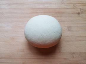 将面絮倒在案板上，揉成光滑的面团。 