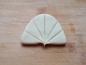 用梳子压出“荷叶”的纹路，用大拇指和食指捏出“荷叶”的叶柄。 