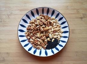 准备好核桃仁、花生仁和黑芝麻，装入保鲜袋用擀面杖压碎。 
