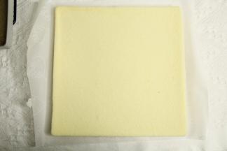 烤完取出轻振2下振出热气，静置2分钟后盖油纸倒扣，抹油的模具可轻松脱模，毛巾面朝上，盖油纸晾至温热