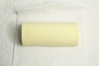 提起油纸，借助擀面杖卷起蛋糕卷，裹好油纸密封冷藏定型。