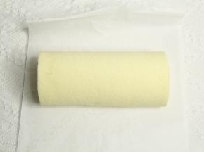 提起油纸，借助擀面杖卷起蛋糕卷，裹好油纸密封冷藏定型。