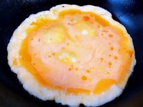 锅中倒入适量底油加热后淋入打散的蛋液炒至鸡蛋八成熟