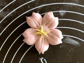 把黄色的细条捏成花芯的样子，沾一点水，把花芯粘在樱花中间。