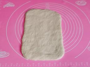 取一块白色面团擀长方形。