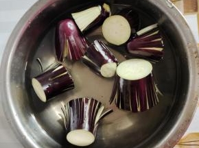 盆子放入适量的清水，加入三勺盐搅拌至融化，放入切好的茄子浸泡20分钟左右！用盐水浸泡过的茄子会变得比较软，不容易折！
