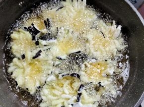 起锅烧油，油温七成热左右，下茄子，一个一个开始炸！中途定型了翻个面继续炸！炸好的茄子就像一朵朵盛开的菊花，特别的漂亮！
