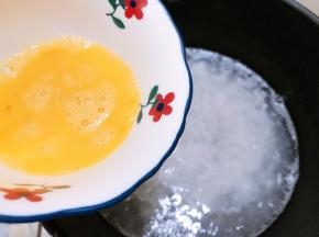 淋入鸡蛋液，一边淋一边用勺子搅拌