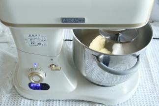 3、开一档混合到无干粉，转4-5档打到面团光滑挂钩。因为是没有加黄油的，直接使用的淡奶油，打面的过程会久一些，如果天气热，需要加冰袋控制面温。