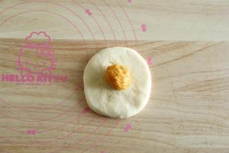 10、取一松弛好的面团，拍扁擀开成圆形，翻面放上馅料球。