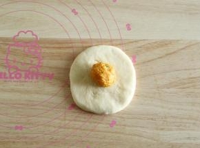 10、取一松弛好的面团，拍扁擀开成圆形，翻面放上馅料球。