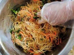 放入胡萝卜丝，黄瓜丝，蒜末，香菜，生抽两大勺，味达美香醋两大勺，盐一勺，鸡精一勺，白糖一勺，香油适量，辣椒油一勺！戴上一次性手套，抓拌均匀！