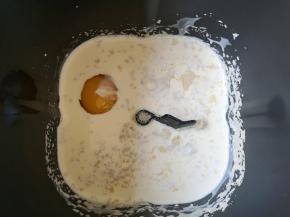 面包机桶内倒入淡奶油和牛奶，打入一个鸡蛋，加入干酵母，搅拌一下让酵母融化。 