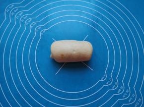 卷起来，一个肉松面包生胚就做好了，以此方法做完剩下的面包面团。