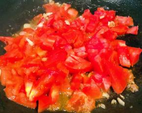 锅中倒入底油加热放入蒜粒爆香再放入西红柿炒出汤汁