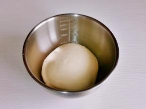 取出面团揉圆，放入器具中。