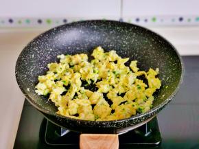 一边用筷子搅拌成絮状，蛋液凝固后盛出备用。