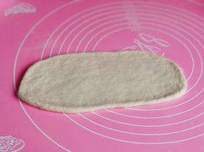 取一块面团用擀面杖擀长舌状。