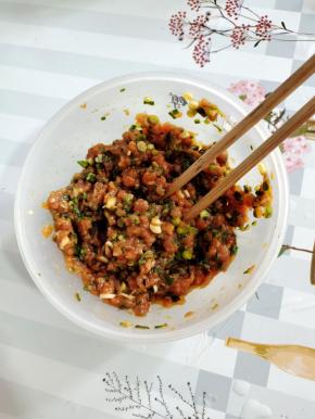 肉馅中放入葱花，生抽，食盐，鸡精，鸡蛋，黑胡椒粉顺时针方向搅拌均匀腌制10分钟左右！