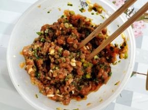 肉馅中放入葱花，生抽，食盐，鸡精，鸡蛋，黑胡椒粉顺时针方向搅拌均匀腌制10分钟左右！